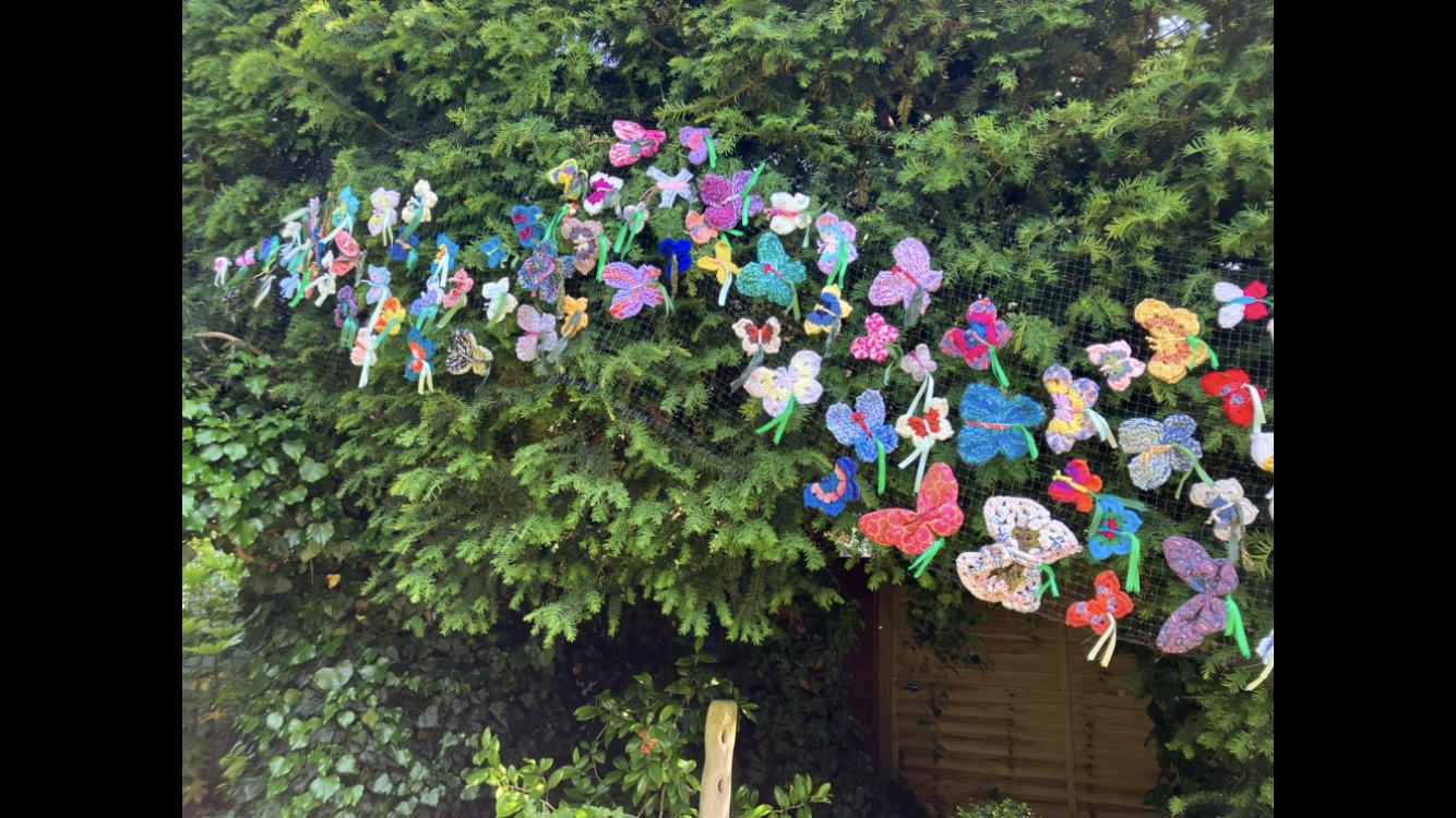 knitted butteflies on a hedge